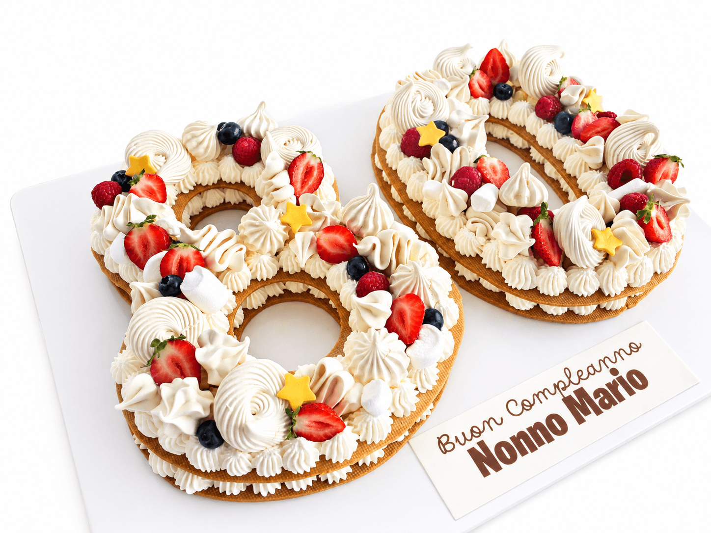 Torta numero 80 con fragole, lamponi e decorazioni bianche