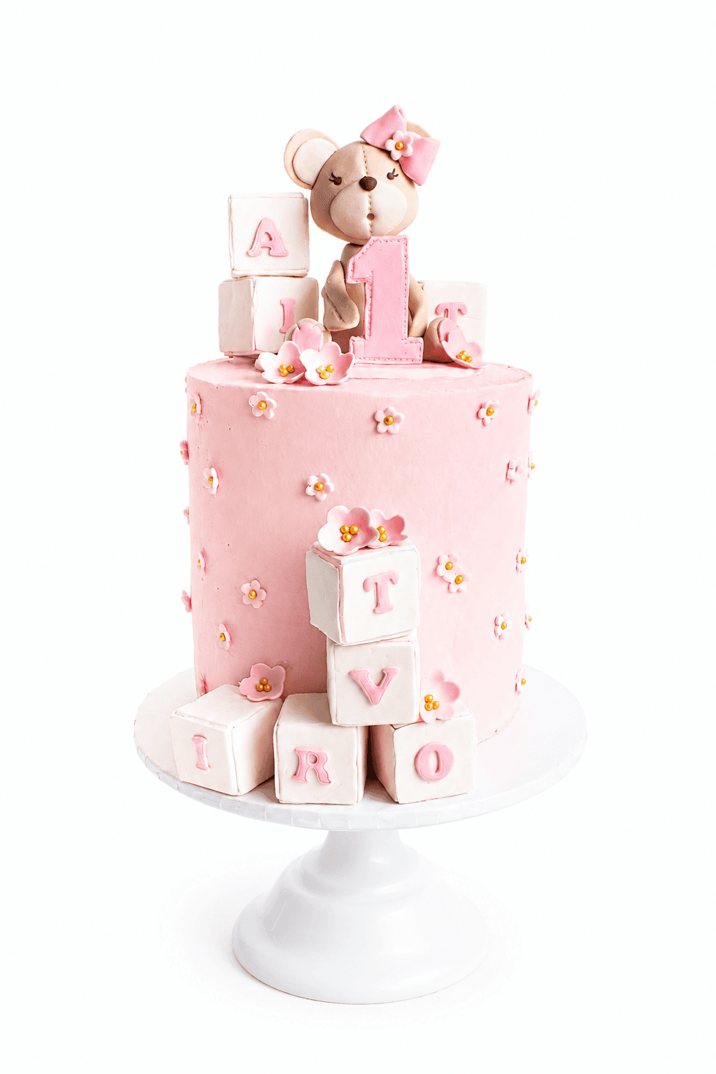 Torta rosa con orsetto, numero 1 e cubi con lettere